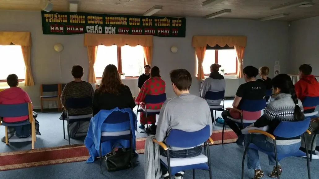 Group meditation with participants seated on chairs facing the teacher