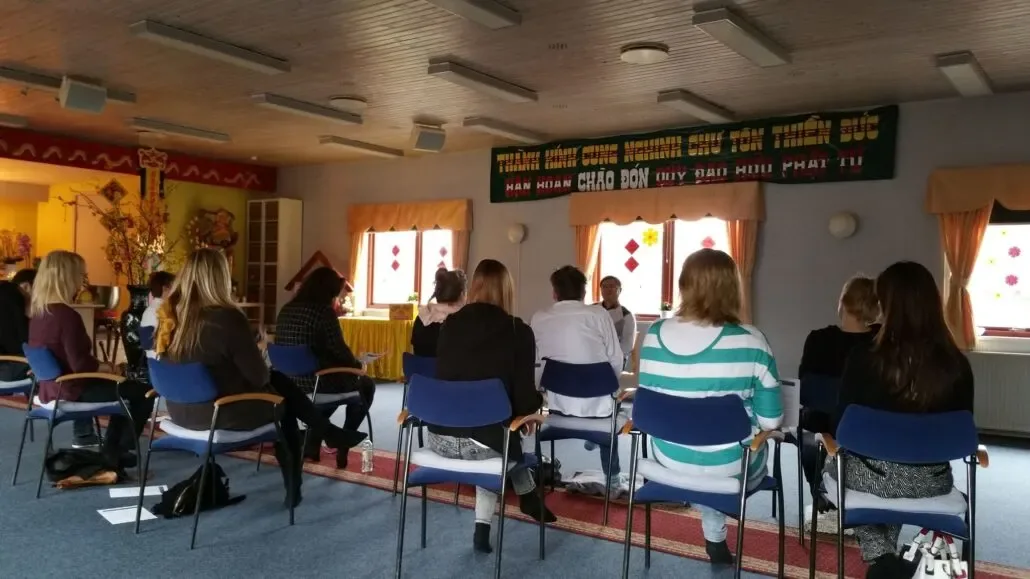 Relaxation session with participants lying on mats in a meditation hall