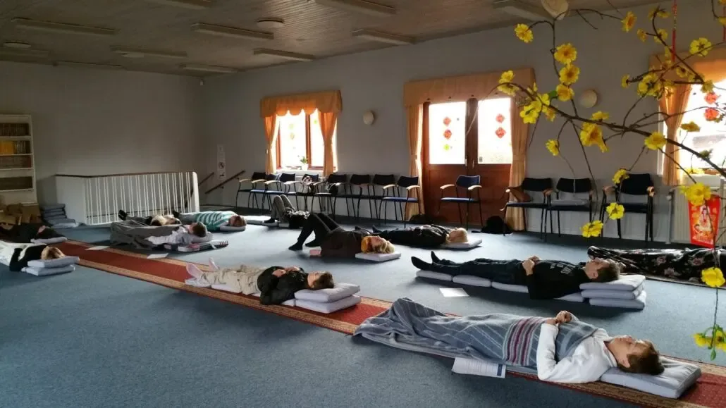 Guided group meditation in a bright hall